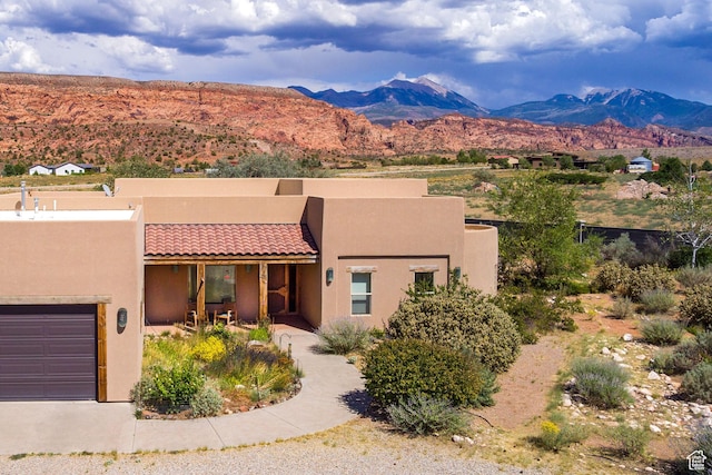 431 E Coronado Ln, Moab, UT 84532 - view of front of house featuring stucco siding, a mountain view, an attached garage, and a tile roof