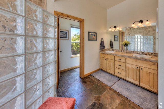 431 E Coronado Ln, Moab, UT 84532 - bathroom with stone tile flooring, double vanity, baseboards, and a sink