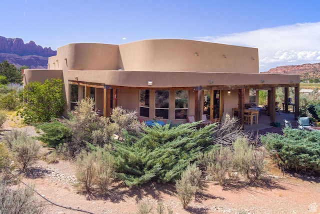 431 E Coronado Ln, Moab, UT 84532 - rear view of house featuring a mountain view, stucco siding, and a patio area