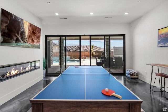recreation room featuring a multi sided fireplace