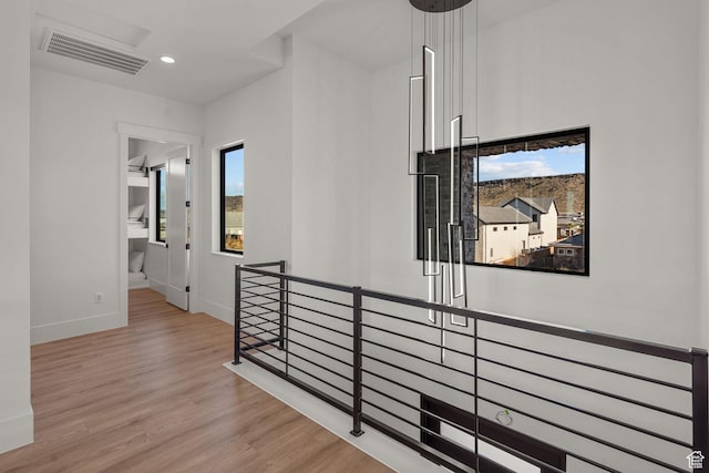 hall featuring plenty of natural light and light hardwood / wood-style floors