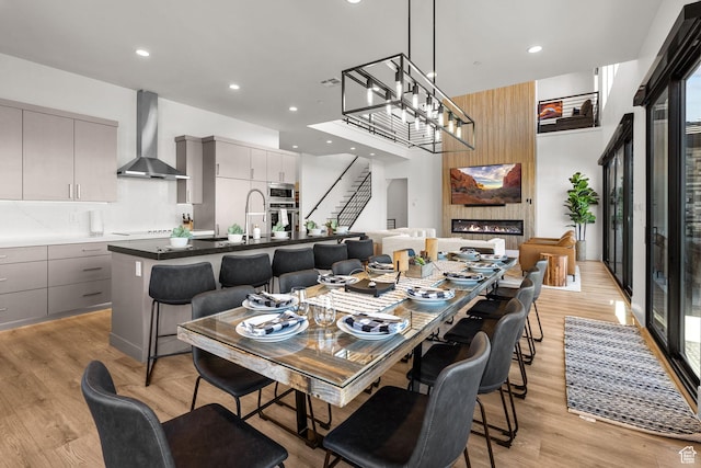 dining space with a large fireplace, sink, and light hardwood / wood-style flooring