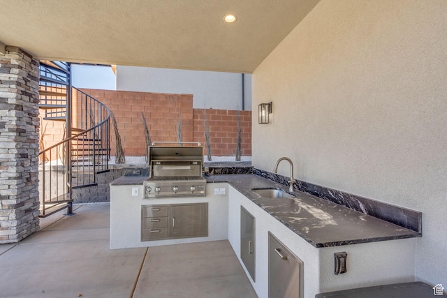 view of patio with area for grilling, sink, and a grill