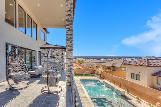 view of swimming pool with pool water feature, an in ground hot tub, and a patio area