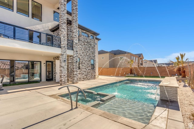 view of swimming pool with an in ground hot tub, pool water feature, and a patio area