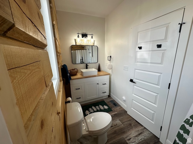 109 Gentle Ben Rd, Fish Haven, ID 83287 - half bathroom featuring wood finished floors, visible vents, toilet, vanity, and baseboards