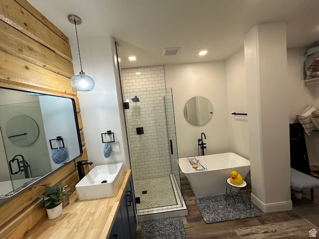 109 Gentle Ben Rd, Fish Haven, ID 83287 - full bath with wood finished floors, a stall shower, a freestanding bath, visible vents, and recessed lighting