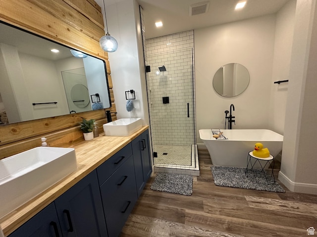 109 Gentle Ben Rd, Fish Haven, ID 83287 - bathroom featuring a shower stall, wood finished floors, visible vents, a sink, and a freestanding tub