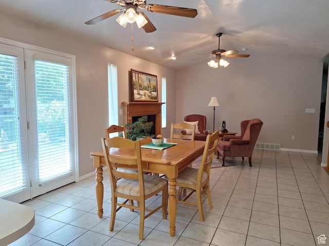 dining room with light tile patterned floors, lofted ceiling, a healthy amount of sunlight, and ceiling fan