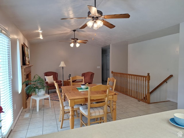 dining space with light tile patterned floors, baseboards, a ceiling fan, and vaulted ceiling