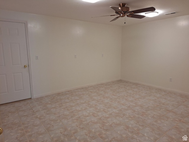 spare room with baseboards, visible vents, and ceiling fan