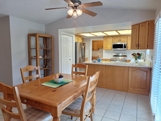 dining room with lofted ceiling, light tile patterned floors, and a ceiling fan
