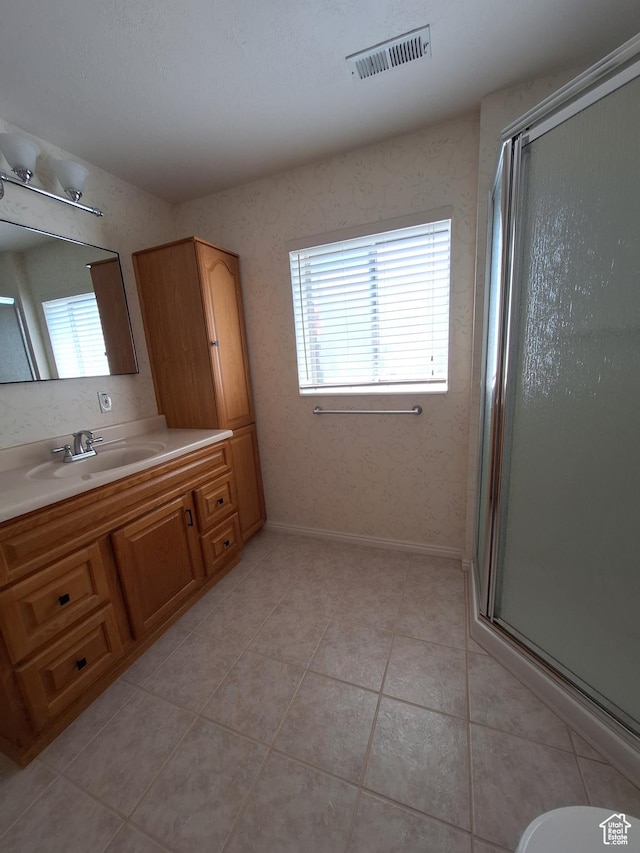 bathroom with tile patterned floors, visible vents, vanity, and a shower stall