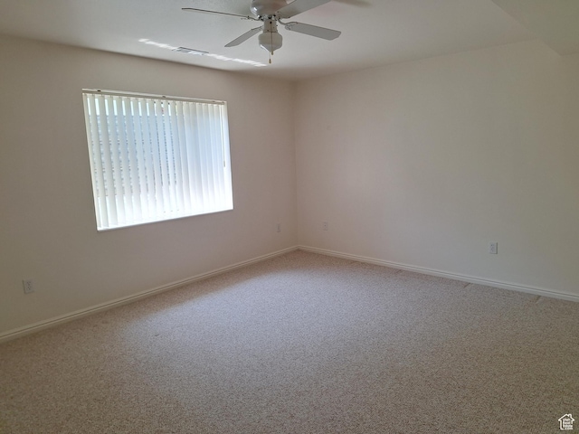carpeted empty room with visible vents, baseboards, and ceiling fan