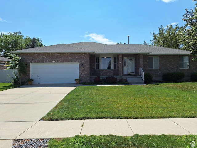 ranch-style house with brick siding, an attached garage, concrete driveway, and a front yard