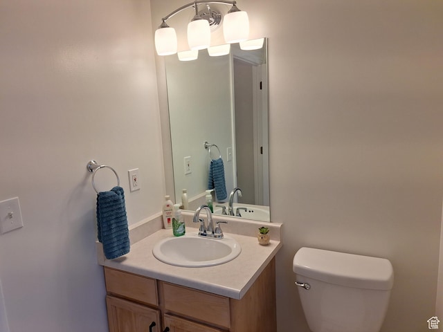 half bath featuring vanity and toilet