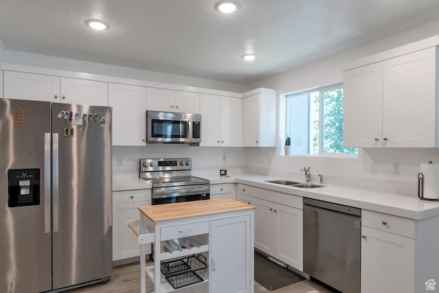 621 Plum Creek Ln, Ogden, UT 84404 - kitchen with a sink, stainless steel appliances, white cabinets, and wood counters