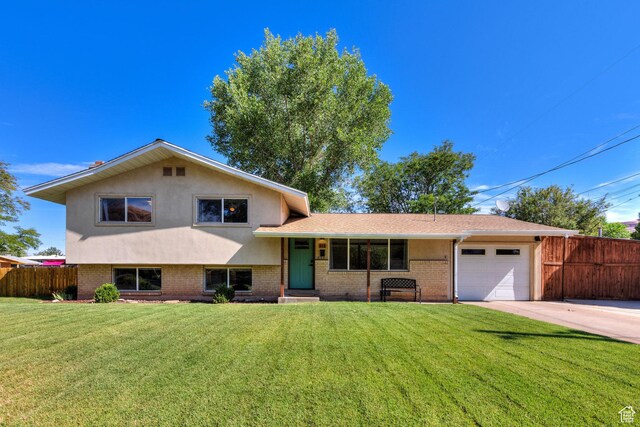 414 W Park Dr W Unit 14, Moab, UT 84532 - split level home with fence, a garage, a front yard, brick siding, and driveway