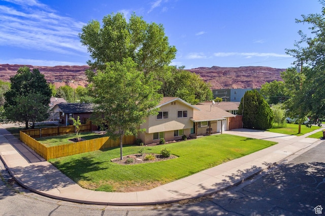 414 W Park Dr W Unit 14, Moab, UT 84532 - view of front of home with a front yard, concrete driveway, a mountain view, and fence