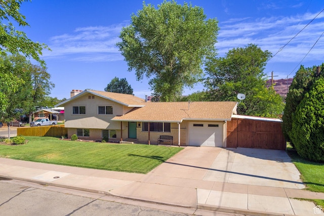 414 W Park Dr W Unit 14, Moab, UT 84532 - tri-level home with fence, an attached garage, driveway, a front yard, and a chimney