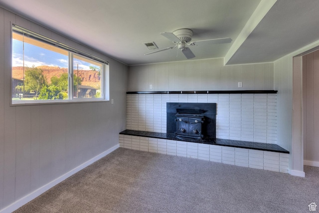 414 W Park Dr W Unit 14, Moab, UT 84532 - unfurnished living room featuring baseboards, carpet, a wood stove, and a ceiling fan