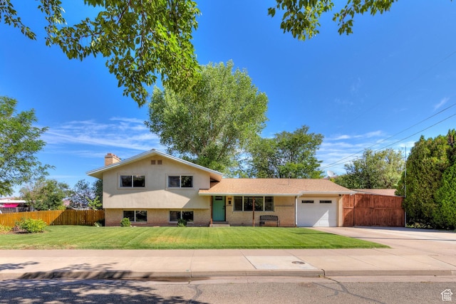 414 W Park Dr W Unit 14, Moab, UT 84532 - tri-level home with an attached garage, fence, and a front lawn