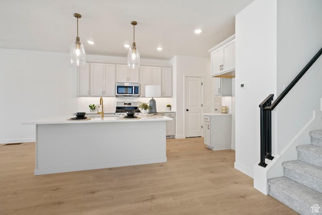 10033 N Torreya Dr Unit 737, Highland, UT 84003 - kitchen with stainless steel appliances, backsplash, light wood finished floors, light countertops, and pendant lighting
