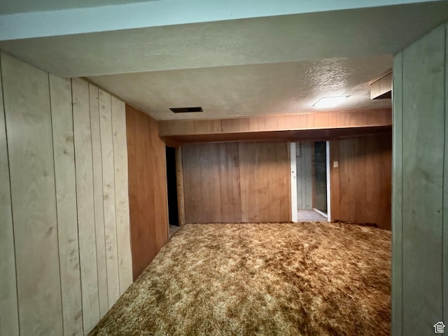 186 S 100 E St E, Laketown, UT 84038 - finished basement with visible vents, light carpet, wooden walls, and a textured ceiling
