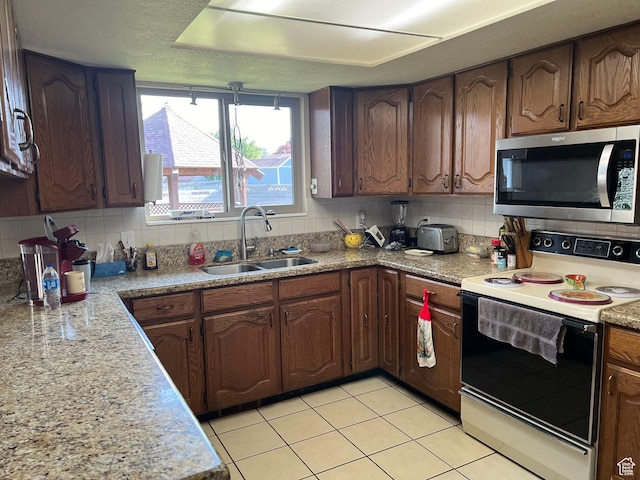 3383 W 6880 S, West Jordan, UT 84084 - kitchen with decorative backsplash, a sink, stainless steel microwave, and electric stove