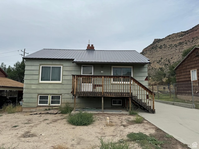 531 Edgehill Dr, Sunnyside, UT 84539 - rear view of property with stairway, a chimney, fence, a wooden deck, and metal roof