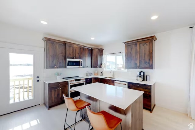 2216 S Beachcomber Ln, Garden City, UT 84028 - kitchen with white appliances, a breakfast bar area, a sink, light countertops, and a center island