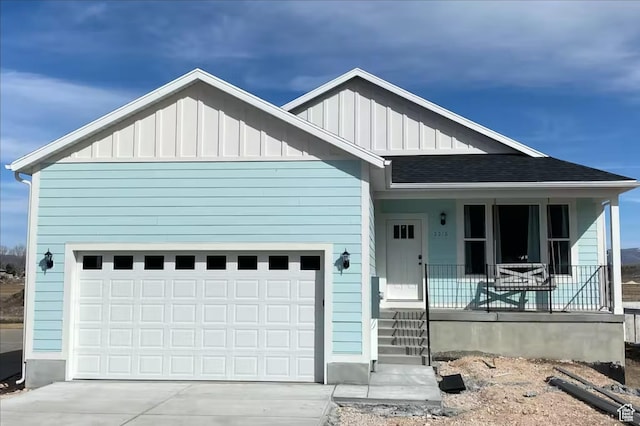 2216 S Beachcomber Ln, Garden City, UT 84028 - view of front of home with board and batten siding, an attached garage, covered porch, and driveway