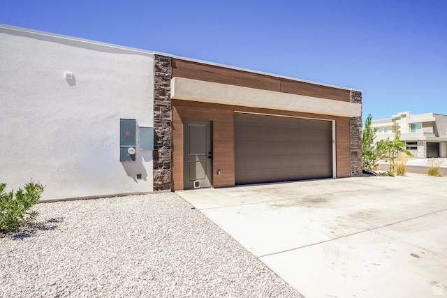 581 W Cypress Umber Dr Unit 34, St George, UT 84790 - view of front of home with a garage, driveway, stucco siding, and stone siding