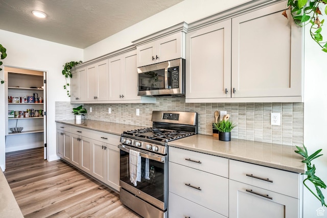 581 W Cypress Umber Dr Unit 34, St George, UT 84790 - kitchen with appliances with stainless steel finishes, light wood finished floors, backsplash, recessed lighting, and light stone countertops