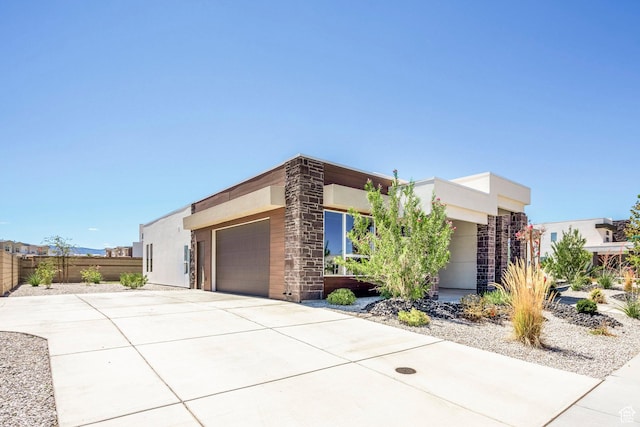 581 W Cypress Umber Dr Unit 34, St George, UT 84790 - view of front of property with fence, a garage, concrete driveway, stone siding, and stucco siding