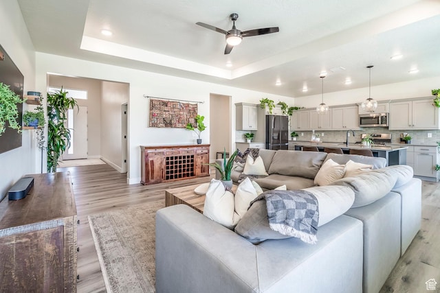 581 W Cypress Umber Dr Unit 34, St George, UT 84790 - living area with a ceiling fan, a tray ceiling, light wood-style floors, baseboards, and recessed lighting