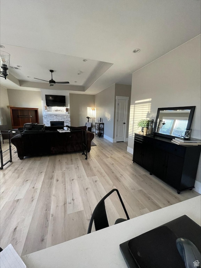2226 S 2925 W, Cedar City, UT 84720 - living area featuring a tray ceiling, a fireplace, ceiling fan, light wood-type flooring, and baseboards