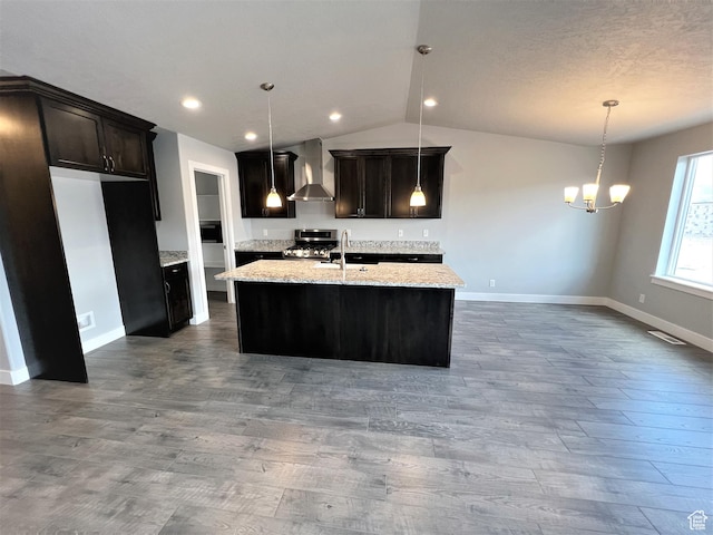 kitchen with baseboards, gas stove, wall chimney range hood, dark wood finished floors, and vaulted ceiling