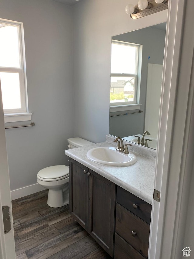 bathroom featuring vanity, baseboards, toilet, and wood finished floors