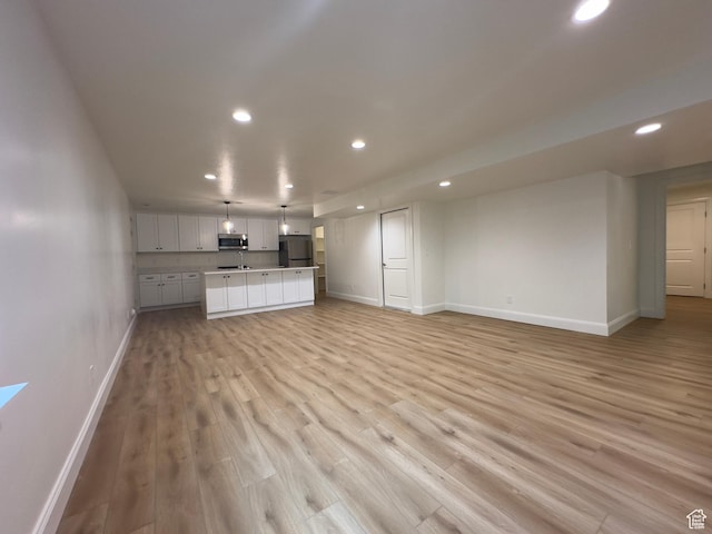 16 W 650 N Unit 1, Salem, UT 84653 - unfurnished living room with recessed lighting, baseboards, and light wood finished floors