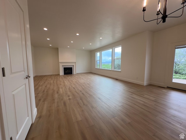 16 W 650 N Unit 1, Salem, UT 84653 - unfurnished living room featuring wood finished floors, recessed lighting, baseboards, a chandelier, and a fireplace