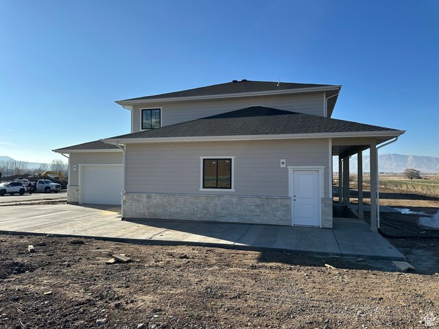 16 W 650 N Unit 1, Salem, UT 84653 - rear view of property featuring a mountain view, driveway, an attached garage, and stone siding