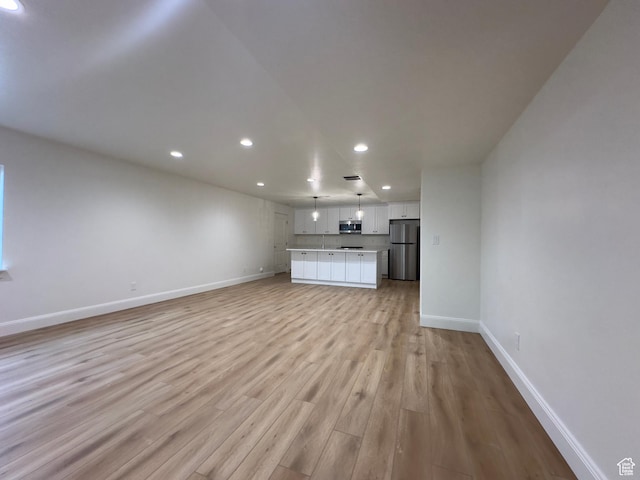 16 W 650 N Unit 1, Salem, UT 84653 - unfurnished living room with recessed lighting, baseboards, and light wood-type flooring