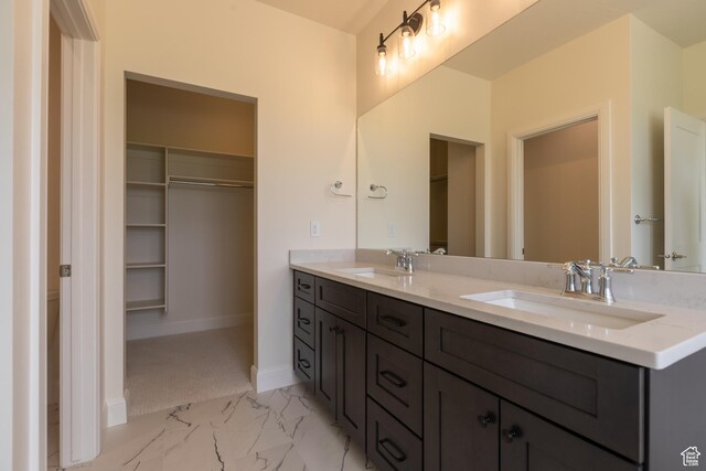 52 W 650 N Unit 3, Salem, UT 84653 - bathroom with double vanity, a walk in closet, marble look tiles, and baseboards