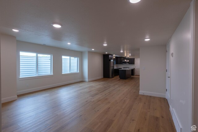 52 W 650 N Unit 3, Salem, UT 84653 - unfurnished living room with recessed lighting, baseboards, and light wood-style floors