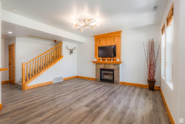1746 W Redstone Ave # G, Park City, UT 84098 - unfurnished living room featuring a stone fireplace and hardwood / wood-style flooring