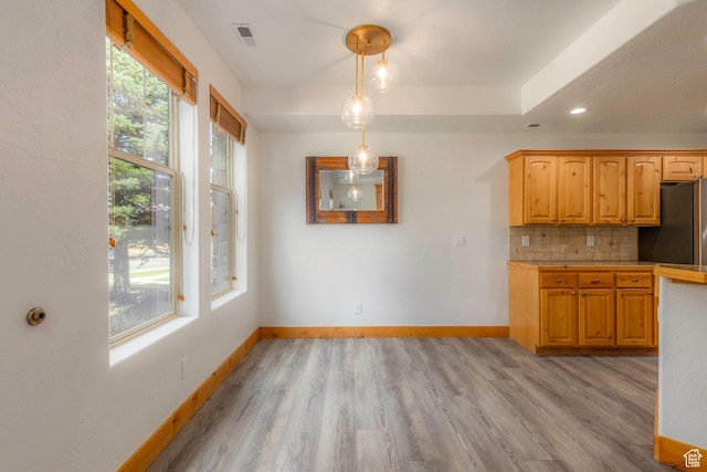 1746 W Redstone Ave # G, Park City, UT 84098 - kitchen with pendant lighting, light hardwood / wood-style flooring, stainless steel refrigerator, and tasteful backsplash