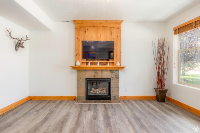 1746 W Redstone Ave # G, Park City, UT 84098 - unfurnished living room featuring hardwood / wood-style flooring and a tiled fireplace