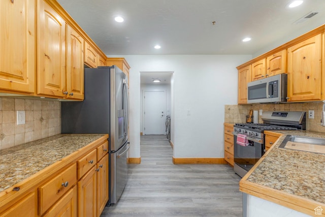 1746 W Redstone Ave # G, Park City, UT 84098 - kitchen with decorative backsplash, appliances with stainless steel finishes, light hardwood / wood-style floors, and sink