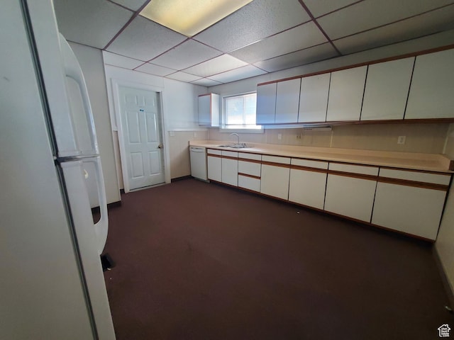 268 S 4th St, Montpelier, ID 83254 - kitchen with white appliances, a sink, light countertops, dark colored carpet, and white cabinets